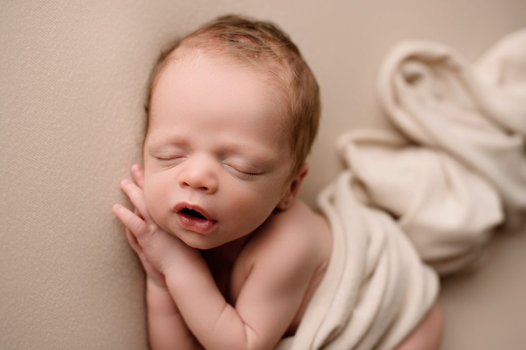 newborn photography of baby sleeping on side in studio