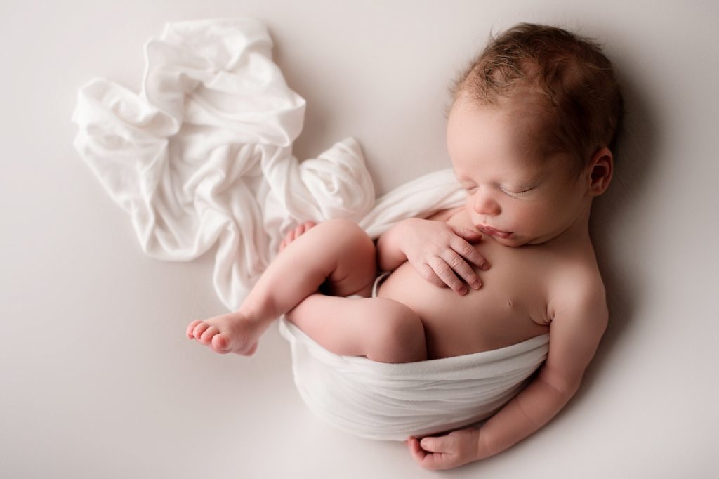 bangor maine studio newborn photographer baby on neutral white backdrop with wrap